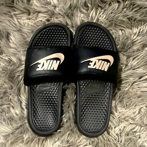 Black Nike slides with pale pink symbol